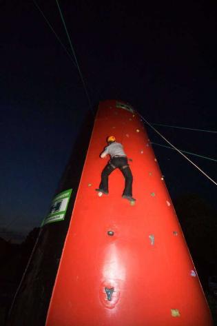 Uczestnicy Konferencji rywalizują na czas na sztucznej ściance wspinaczkowej podczas biesiady grillowej