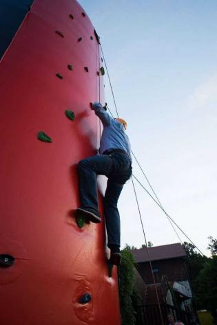 Uczestnicy Konferencji rywalizują na czas na sztucznej ściance wspinaczkowej podczas biesiady grillowej